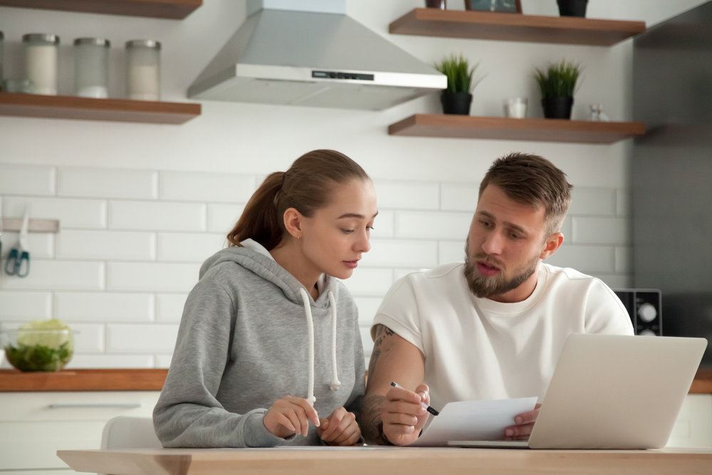 Man and woman discussing at kitchen table