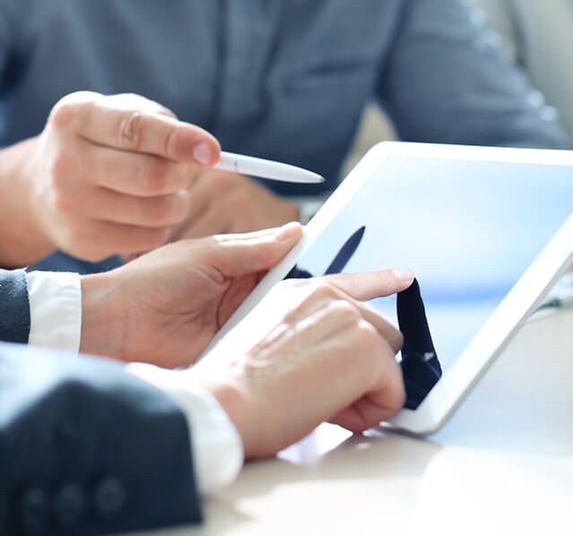 two people analyzing information on a tablet