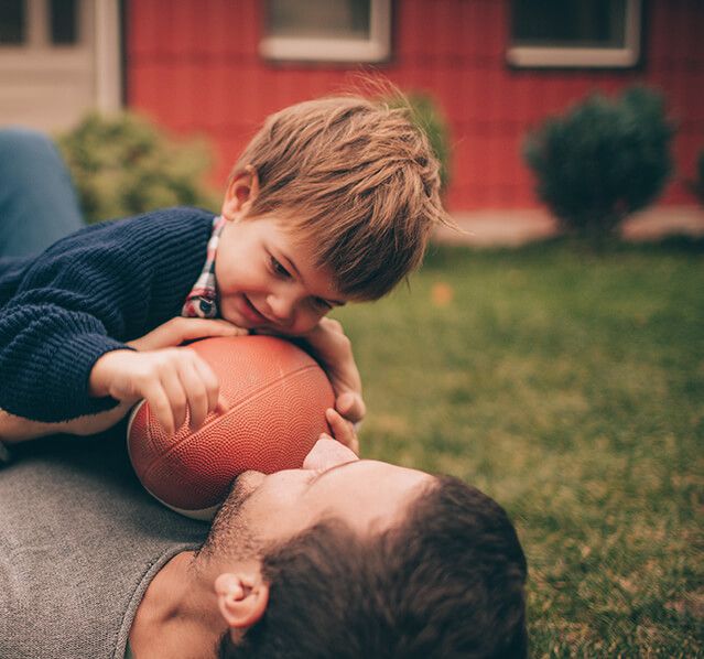 father and son playing football